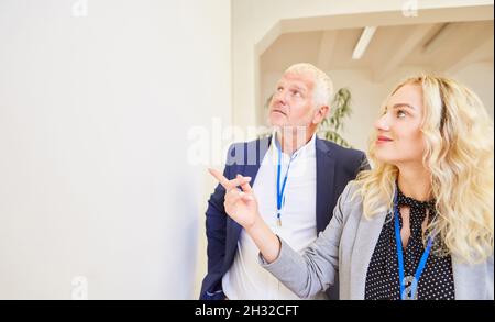 Zwei Geschäftsleute mit Namensschildern und Personalausweis machen einen Rundgang durch die Messe Stockfoto