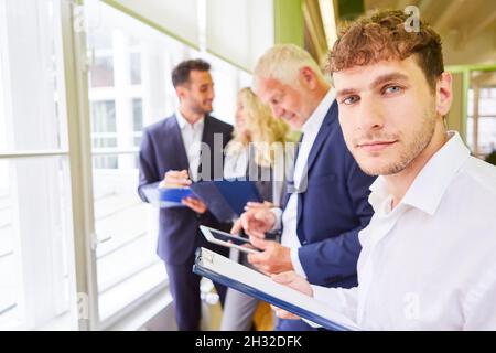 Junger Mann als Gründerin und Team im Strategie-Workshop mit Checkliste Stockfoto