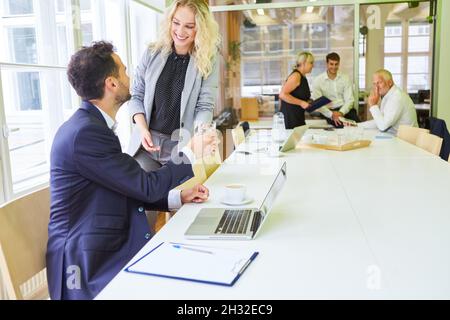 Kollegen aus dem Geschäftsteam arbeiten im Büro auf einem Laptop zusammen Stockfoto
