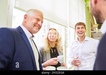 Die Kollegen im Business-Team im Büro haben während einer Kaffeepause viel Spaß beim Small Talk Stockfoto