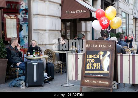 London, Großbritannien - 20. September 2021, die Menschen sind im Café. Ein Mann und eine Frau trinken Bier, während sie an einem Tisch auf der Straße in der Nähe der Bella Italia r sitzen Stockfoto