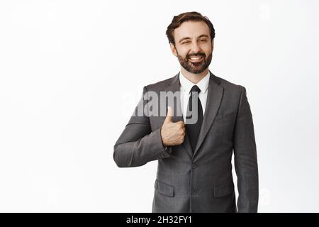 Geschäftsleute. Erfolgreicher männlicher Unternehmer, ceo-Manager zeigt Daumen nach oben, lächelt und zwinkelt, um den Kunden zu ermutigen, weißer Hintergrund Stockfoto