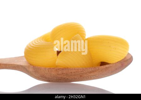 Hellgelbe, ungekochte Pasta mit einem Holzlöffel, Nahaufnahme, isoliert auf Weiß. Stockfoto