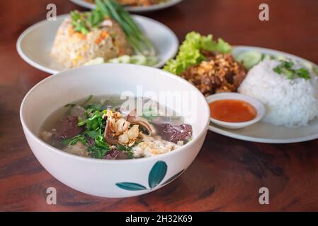 asiatische Küche, Reis und Suppe mit Schweinefleisch in einer Schüssel Stockfoto