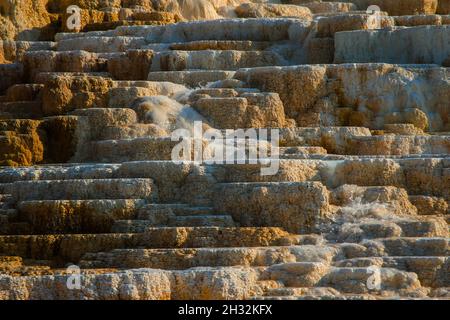 Yellowstone Mammoth Hot Springs Terrasse Wasserfluss Nahaufnahme atemberaubende Details | wunderschöne Travertin-Formationen, bunte Wasserpools, helles Sonnenlicht Stockfoto