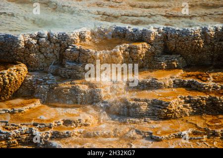 Yellowstone Mammoth Hot Springs Terrasse Wasserfluss Nahaufnahme atemberaubende Details | wunderschöne Travertin-Formationen, bunte Wasserpools, helles Sonnenlicht Stockfoto