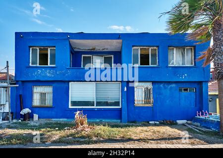 Urla, Türkei - September, 2021: Verlassene zweistöckige ägäische Haus mit blauen Wänden. Stockfoto