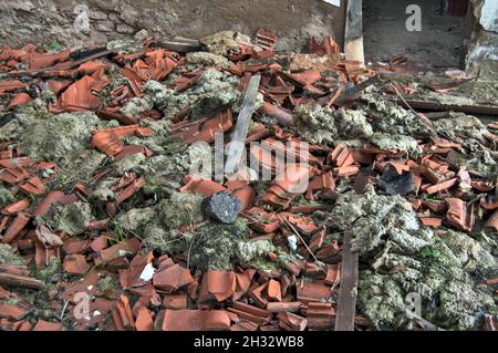 Ein großer Stapel zerbrochener Dachziegel und das Dach des Gebäudes nach dem Brand. Stockfoto