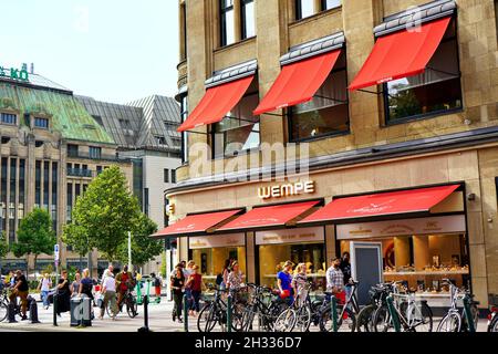 Geschäftige Stadtszene in der Düsseldorfer Innenstadt, mit Kaufhof und Juweliergeschäft „Wempe“. Stockfoto