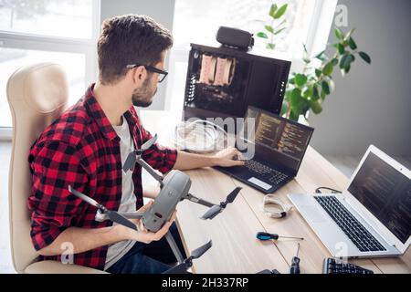 Profil Seitenansicht Porträt von attraktiven smart fokussierten Kerl Fixierung Drohne schreiben Code-Programmierung am Arbeitsplatz Station in Innenräumen Stockfoto