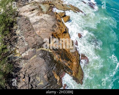 Luftaufnahme mit Wellen, Felsen und Pinien, Praia da Barra, Garopaba, Santa Catarina, Brasilien Stockfoto