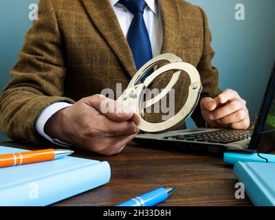 Konzept der Finanzkriminalität. Ein Mann in einem Anzug gibt Handschellen. Stockfoto