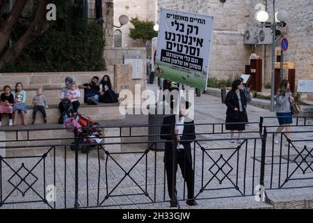 Ein religiöser Jude hält ein Schild mit der Aufschrift „Ein glückseliges Leben ist nur ohne Internet und Filme“ im jüdischen Viertel in der Altstadt von Jerusalem, Israel. Haredi-Gemeinden meiden routinemäßig moderne Technologien wie Internet und Smartphones. Ihre Argumentation ist, dass die immense Menge an Informationen korrumpieren kann, und mit der Fähigkeit, das Internet ohne Beobachtung durch die Gemeinschaft zu nutzen, kann zu Individuation führen. Stockfoto