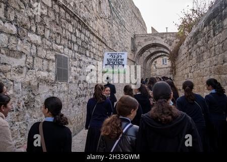 Ein religiöser Jude hält ein Schild mit der Aufschrift „Ein glückseliges Leben ist nur ohne Internet und Filme“, während er durch eine Gasse im jüdischen Viertel in der Altstadt von Jerusalem, Israel, geht. Haredi-Gemeinden meiden routinemäßig moderne Technologien wie Internet und Smartphones. Ihre Argumentation ist, dass die immense Menge an Informationen korrumpieren kann, und mit der Fähigkeit, das Internet ohne Beobachtung durch die Gemeinschaft zu nutzen, kann zu Individuation führen. Stockfoto