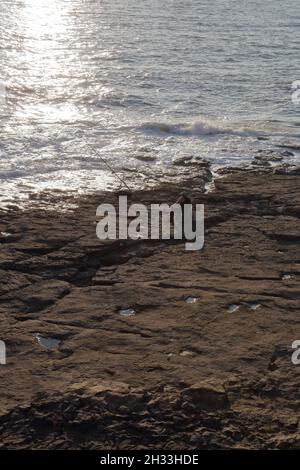 Ein Tag Angeln, geduldig saß warten, dass immer schwer fassbare Schlepper auf der Linie direkt über dem Wasser krachend auf den Felsen. Stockfoto