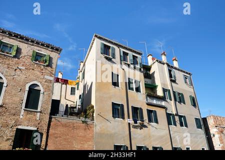 Wäscheleinen in einer Gasse in Venedig, Italien. Wäsche hängt an einer Wäscheleine zwischen den Stadtgebäuden. Stockfoto