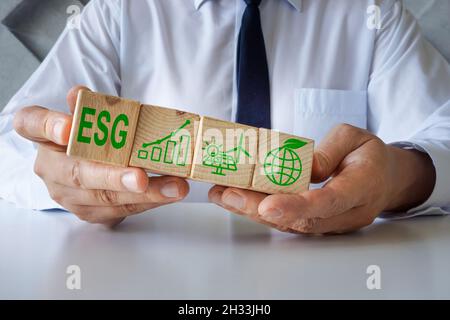 Manager zeigt Würfel mit ESP-Symbolen für Umwelt, Soziales und Corporate Governance. Stockfoto