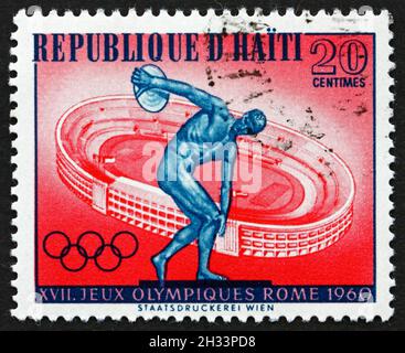 HAITI - UM 1960: Eine in Haiti gedruckte Briefmarke zeigt Diskuswerfer und das Stadion von Rom, 17. Olympische Spiele, Rom, um 1960 Stockfoto