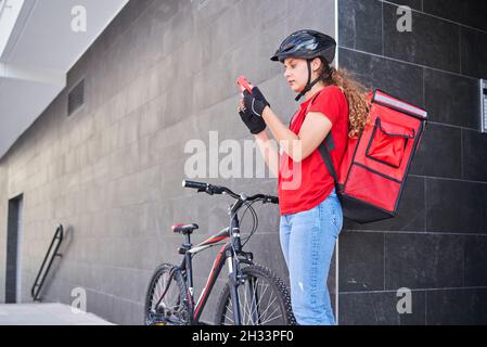 Ein Mädchen, das von einem Radfahrer geliefert wurde, klingelte die Klingel der Sprechanlage Stockfoto