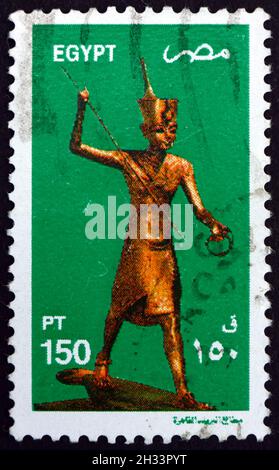 ÄGYPTEN - UM 1982: Eine in Ägypten gedruckte Briefmarke zeigt König Tutanchamen als Harpooner, eine Goldene Statue von König Tutanchamen, um 1982 Stockfoto