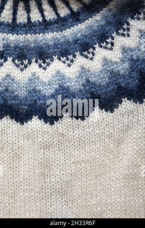 Nahaufnahme des Strickpullovers aus isländischer Schafwolle oder Lopapeysa in Weiß und Blau. Schönes Muster und Strickstruktur. Stockfoto