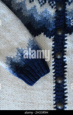 Nahaufnahme des Strickpullovers aus isländischer Schafwolle oder Lopapeysa in Weiß und Blau. Schönes Muster und Strickstruktur. Stockfoto