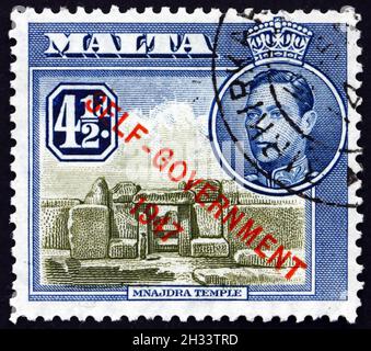 MALTA - UM 1948: Eine in Malta gedruckte Marke zeigt den Mnajdra-Tempel, ein megalithischer Tempelkomplex, der an der Südküste von Malta um 1948 gefunden wurde Stockfoto