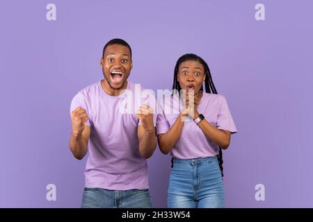 Wow, Ja. Porträt eines überglücklich jungen schwarzen Mannes und einer Frau mit offenem Mund, der jubelt und die Kamera anstarrt. Überrascht überrascht überrascht Paar posiert Isol stehen Stockfoto