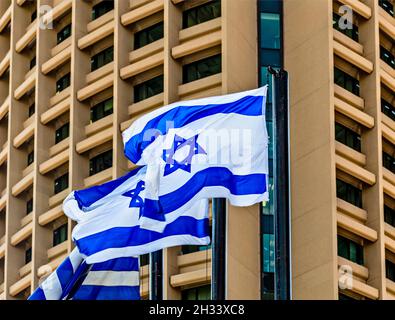 Israelische Flaggen auf dem Hintergrund des Baus in Tel Aviv Magen David unterschreibt den Unabhängigkeitstag Israels, Davids Stern Stockfoto