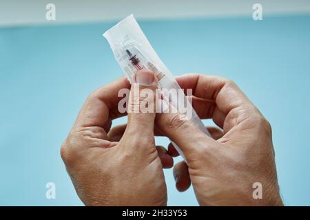 Hände Auspacken einer Spritze aus der Nähe. Hochwertige Fotos Stockfoto