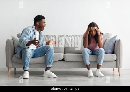 Zerbrechen Und Scheidung Konzept. Junge verheiratete schwarze Paar kämpfen, Kerl schreiend weinende Dame, gestikulieren zu Hause. Wütender Mann, der sein W Stockfoto