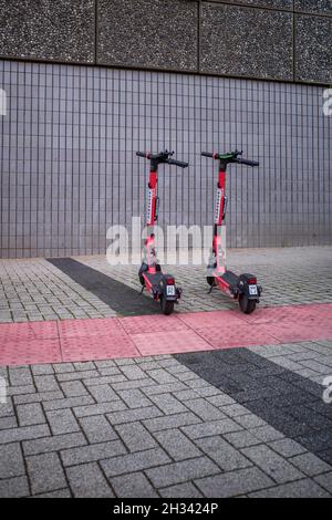 Zwei E-Scooter parkten auf einem Fußweg, um für ihre nächsten Fahrer bereit zu sein. Stockfoto