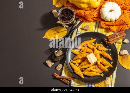 Faule Kürbisknödel, Gnocchi mit Butter und braunem Zucker. Warmes Herbstgericht, süße gesunde Lebensmittel. Schwarzer Stein Beton Hintergrund, trendy hartes Licht, Stockfoto