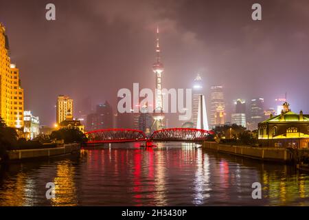 Nachtansicht der Waibaidu Brücke über den Suzhou Creek und den Lujiazui Bezirk von Shanghai, China. Stockfoto