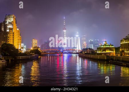 Nachtansicht der Waibaidu Brücke über den Suzhou Creek und den Lujiazui Bezirk von Shanghai, China. Stockfoto