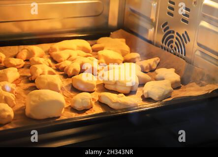 Frisch gebackenes Gebäck. Süße Brötchen im elektrischen Ofen. Kochvorgang. Stockfoto