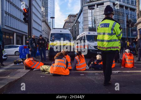 London, Großbritannien. Oktober 2021. Beleidigung Großbritanniens Demonstranten klebten sich an die Straße und blockierten die Wormwood Street und Bishopsgate in der Nähe der Liverpool Street Station. Die Demonstranten fordern, dass die Regierung bis 2025 alle sozialen Wohnungsbauten isoliert und die Verantwortung dafür übernimmt, dass alle Häuser im Vereinigten Königreich bis 2030 energieeffizienter sind, als Teil der umfassenderen Ziele für den Klimawandel und die Dekarbonisierung. Stockfoto