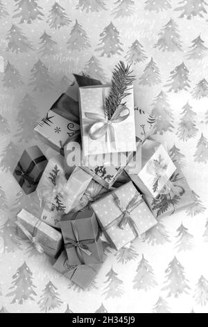 Draufsicht Haufen von Weihnachten DIY Geschenkschachteln in verschiedenen Formen und Größen auf festlichen Geschenkpapieren mit Fichten und Inschriften Frohe Weihnachten. Weihnachten Backdr Stockfoto