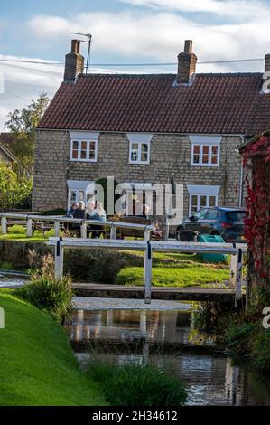 Das malerische Dorf Hovingham mit einem Bach, „Brookside“, an der Grenze zum Yorkshire Moors National Park und den Howardian Hills in North Yorksh Stockfoto