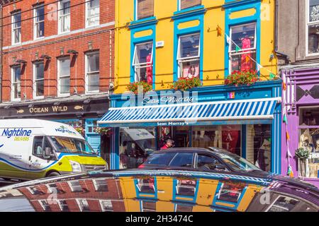 Skibbereen, County Cork, Republik Irland. Irland. Farbenfrohe Ladenfronten an der Main Street. Stockfoto