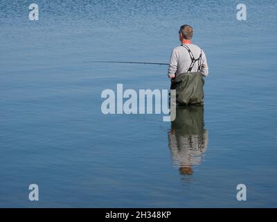 Mann, der in Christchurch Harbour, Dorset, Großbritannien angeln will Stockfoto