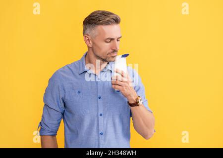 haarpflege und Hautpflege. Präsentation kosmetisches Produkt für Männer. Mann verwenden Duschgel. Stockfoto