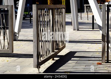 Moderne pulverbeschichtete Aluminium niedrigen Zaun und Drehtor auf Stahl.post Pivot. Straßenlandschaft Hintergrund. Stein gepflastert Bürgersteig. Abnehmende Perspektive. Stockfoto