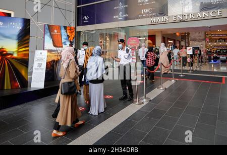 Kuala Lumpur, Malaysia. Okt. 2021. Sicherheitspersonal mit Gesichtsmasken wird gesehen, wie sie mit den Käufern sprechen, bevor sie ihnen den Eintritt in das Einkaufszentrum in Kuala Lumpur erlauben. (Foto von Wong Fok Loy/SOPA Images/Sipa USA) Quelle: SIPA USA/Alamy Live News Stockfoto