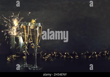 Sektgläser mit bengallichtern-Dekoration auf dunklem Hintergrund Stockfoto