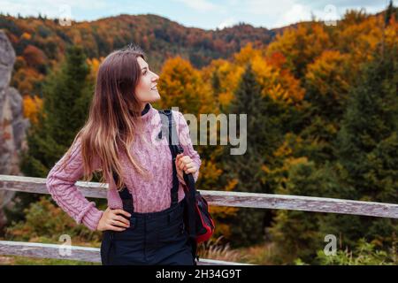 Frau Reisende mit Rucksack genießt Felsen und Wald im Herbst Karpaten Berge. Herbst Tourismus in der Ukraine Stockfoto