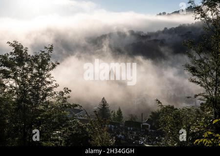 Am frühen Morgen bedeckt der Nebel das Dorf Saint-Étienne-de-Baïgorry, von der Landstraße aus gesehen, die zum Col d'Izpégi, Frankreich, führt Stockfoto
