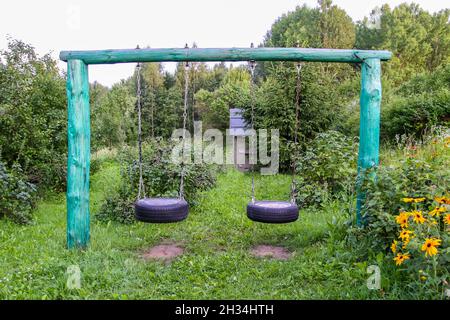 Selbstmades Flügel aus Reifen und Metallketten im Sommergarten. Stockfoto