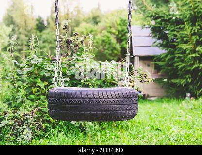 Selbstmades Flügel aus Reifen und Metallketten im Sommergarten. Stockfoto