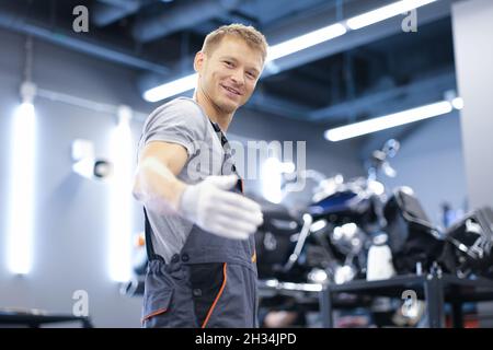 Lächelnder junger Automechaniker steht in der Werkstatt aus der Nähe Stockfoto